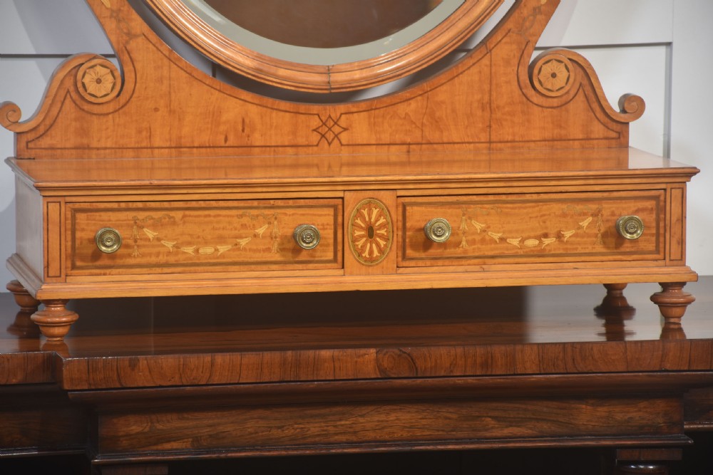 An oval satinwood dressing table mirror featuring marquetry inlay, curved supporting arms, and a two-drawer base resting on short turned feet. View III