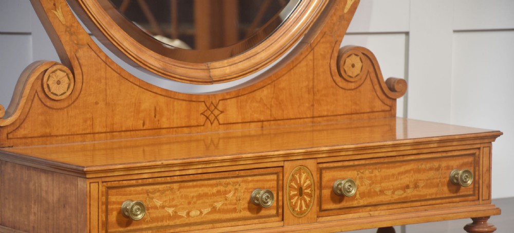 An oval satinwood dressing table mirror featuring marquetry inlay, curved supporting arms, and a two-drawer base resting on short turned feet. View VII