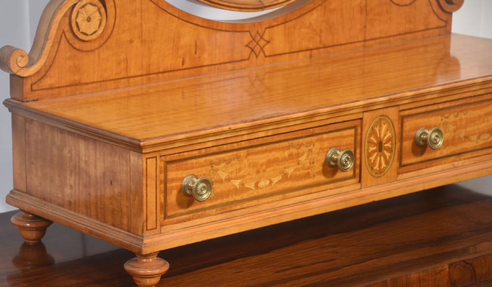 An oval satinwood dressing table mirror featuring marquetry inlay, curved supporting arms, and a two-drawer base resting on short turned feet. View IX
