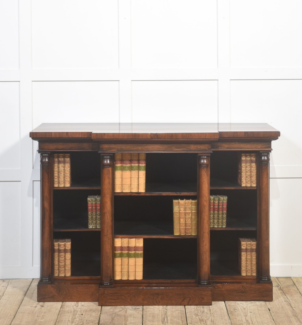 A nineteenth-century rosewood breakfront open bookcase with a projecting centre section flanked by turned column pilasters.