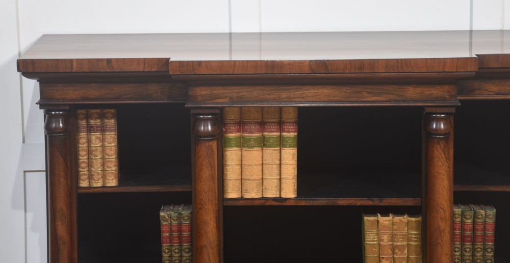 A nineteenth-century rosewood breakfront open bookcase with a projecting centre section flanked by turned column pilasters. View III