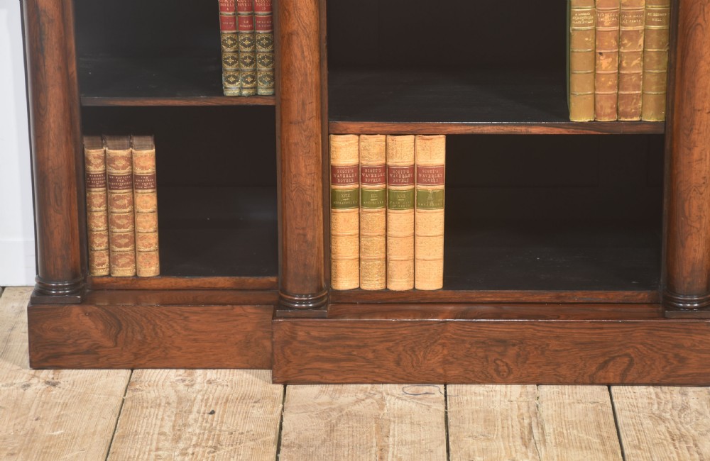 A nineteenth-century rosewood breakfront open bookcase with a projecting centre section flanked by turned column pilasters. View VI