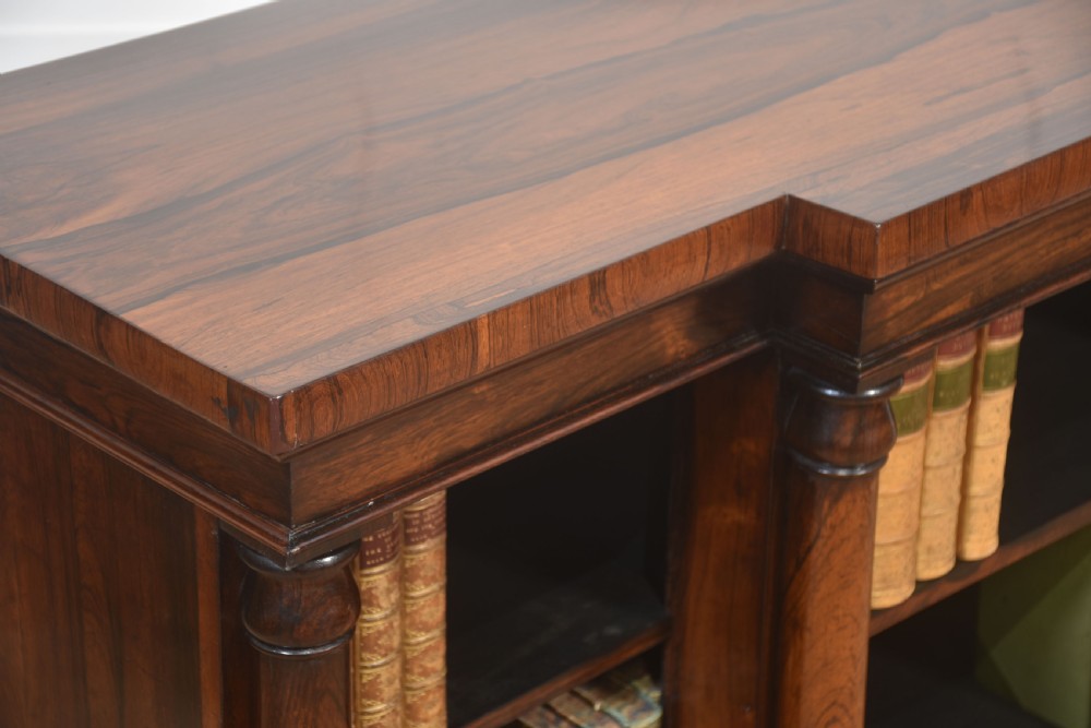 A nineteenth-century rosewood breakfront open bookcase with a projecting centre section flanked by turned column pilasters. View IX
