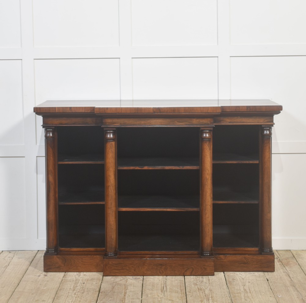 A nineteenth-century rosewood breakfront open bookcase with a projecting centre section flanked by turned column pilasters. View X