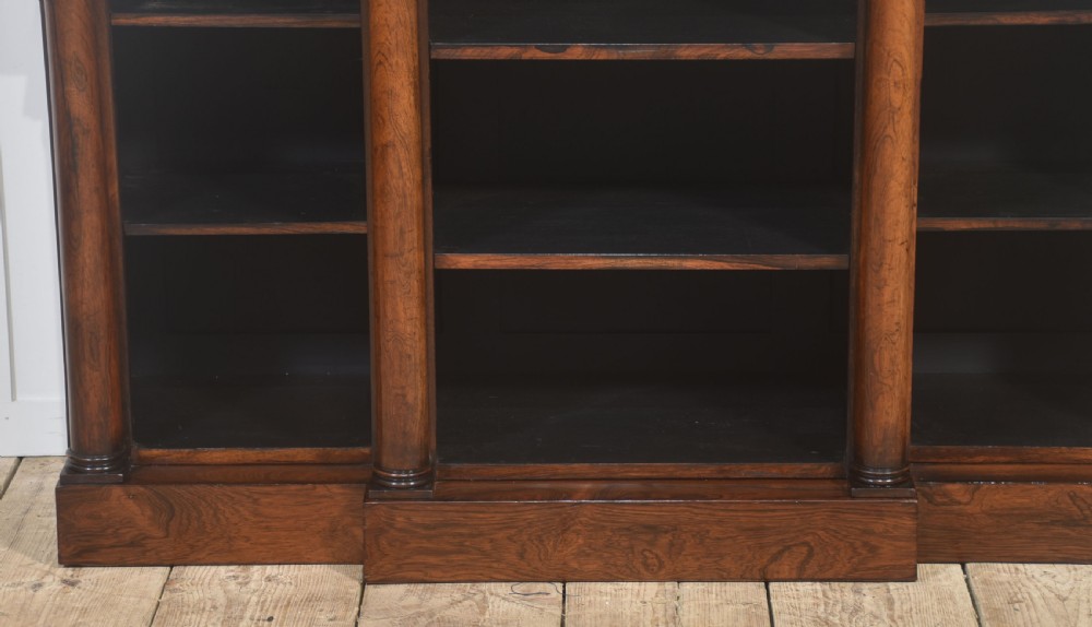 A nineteenth-century rosewood breakfront open bookcase with a projecting centre section flanked by turned column pilasters. View XII