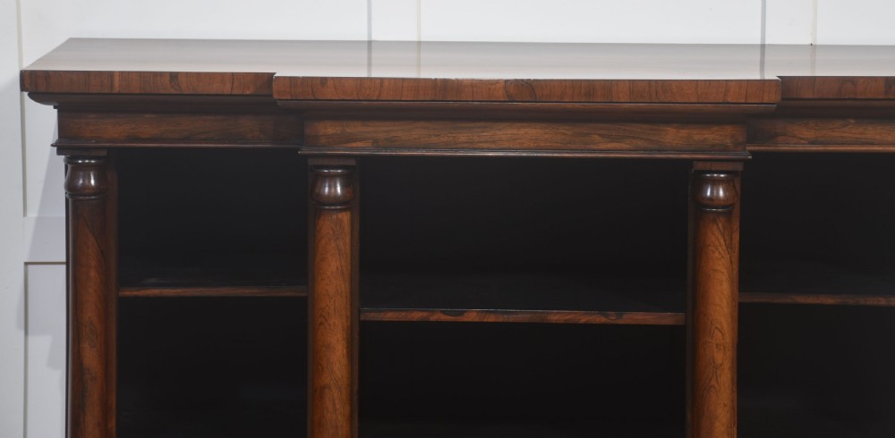 A nineteenth-century rosewood breakfront open bookcase with a projecting centre section flanked by turned column pilasters. View XIII