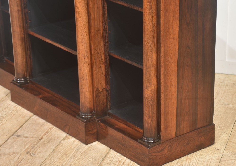 A nineteenth-century rosewood breakfront open bookcase with a projecting centre section flanked by turned column pilasters. View XVII