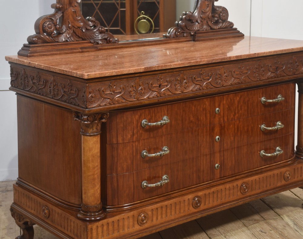 A 19th-century mahogany dressing chest featuring three flame mahogany drawers, carved sphinx supports framing a tall rectangular mirror, a marble top, and brass handles. View X