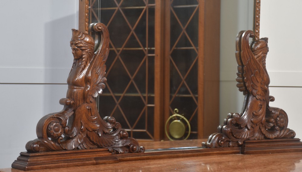 A 19th-century mahogany dressing chest featuring three flame mahogany drawers, carved sphinx supports framing a tall rectangular mirror, a marble top, and brass handles. View XI