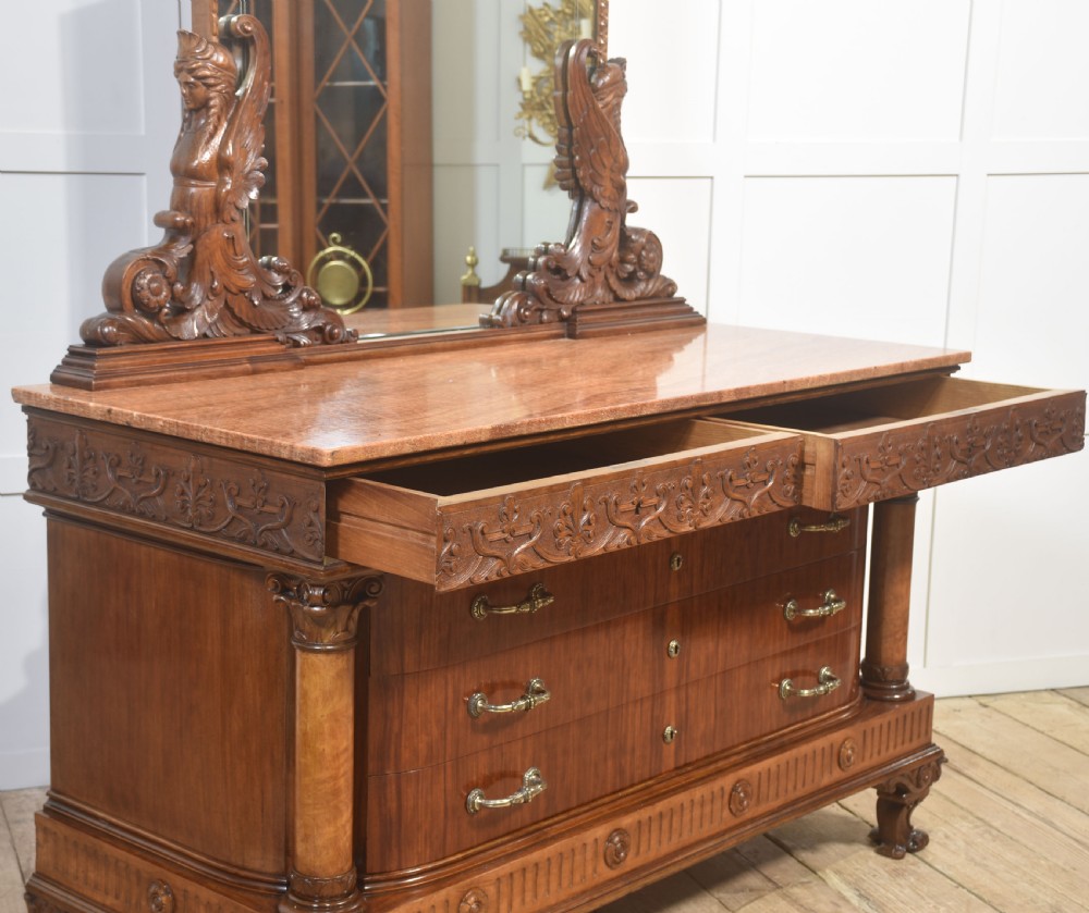 A 19th-century mahogany dressing chest featuring three flame mahogany drawers, carved sphinx supports framing a tall rectangular mirror, a marble top, and brass handles. View XVI