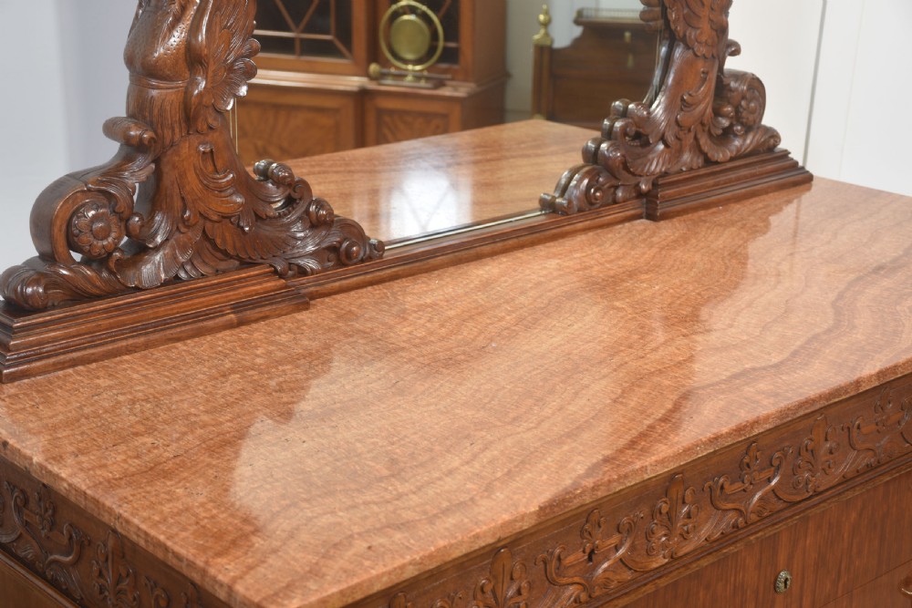 A 19th-century mahogany dressing chest featuring three flame mahogany drawers, carved sphinx supports framing a tall rectangular mirror, a marble top, and brass handles. View XVII