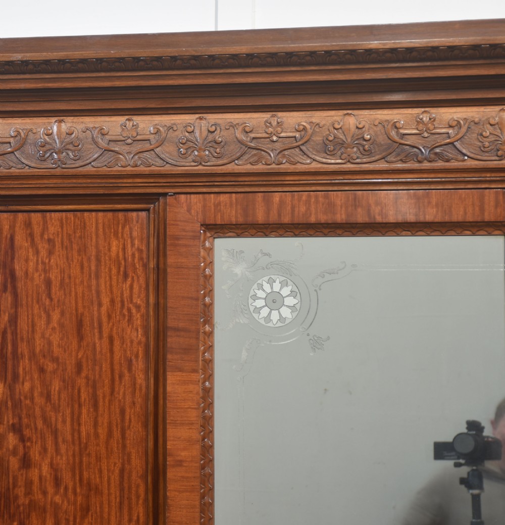 Large Victorian mahogany four-door wardrobe with central etched mirror doors, carved frieze, fluted side columns, and bracket feet. View II