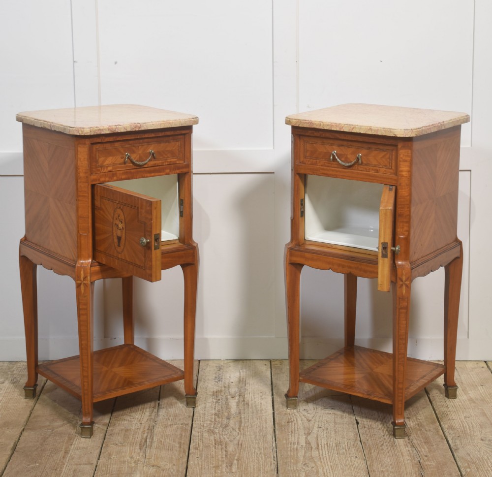 A pair of tall French satinwood bedside cabinets with marble tops, marquetry oval medallions, drawers, and slender legs. View VIII