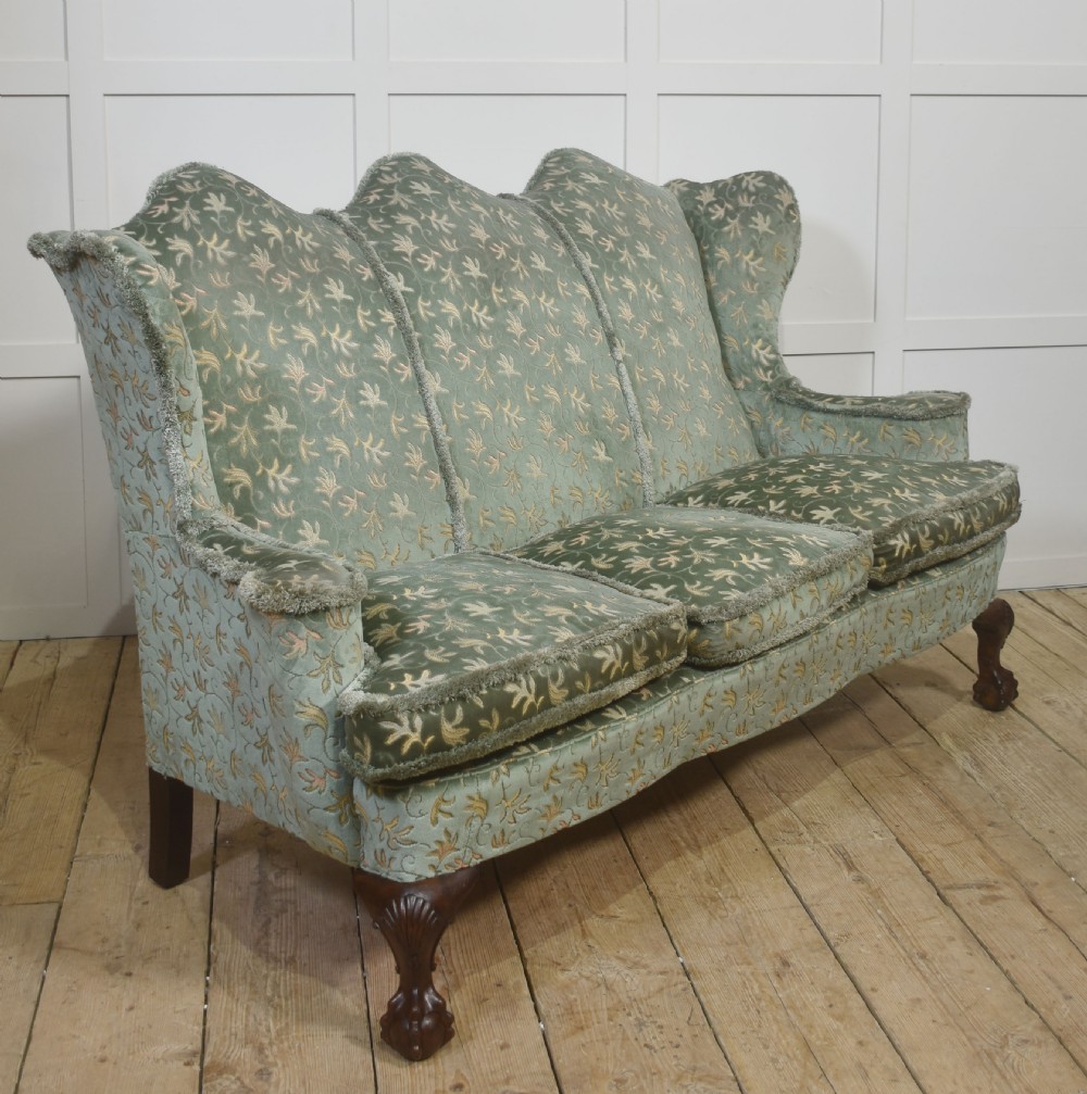 A Queen Anne style three-seat wingback sofa upholstered in patterned green fabric with carved cabriole legs and ball-and-claw feet. View II