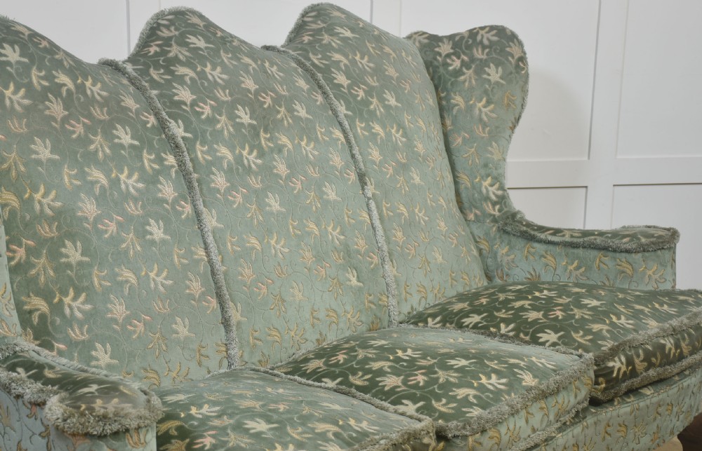 A Queen Anne style three-seat wingback sofa upholstered in patterned green fabric with carved cabriole legs and ball-and-claw feet. View V