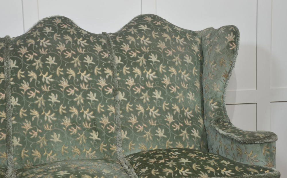 A Queen Anne style three-seat wingback sofa upholstered in patterned green fabric with carved cabriole legs and ball-and-claw feet. View VI