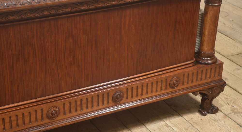 A carved mahogany super king size bed frame featuring architectural columns, a high headboard with flame mahogany panel, and carved decorative details. View III