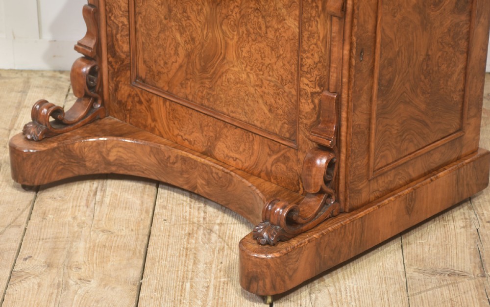 A Victorian burr walnut Davenport desk featuring a pop-up stationery cabinet decorated with floral marquetry, a sloped write top, and carved scroll supports. View X