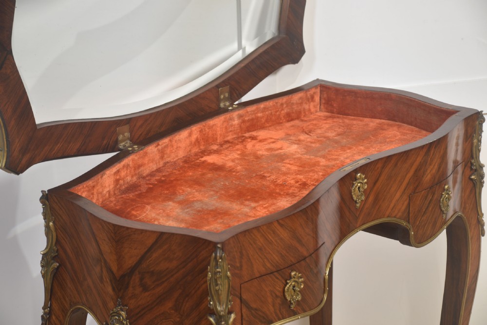 A French Louis XV style kingwood bijouterie table featuring a glazed display lid, curved aprons with gilt-bronze escutcheons, and slender cabriole legs with brass mounts. View XI