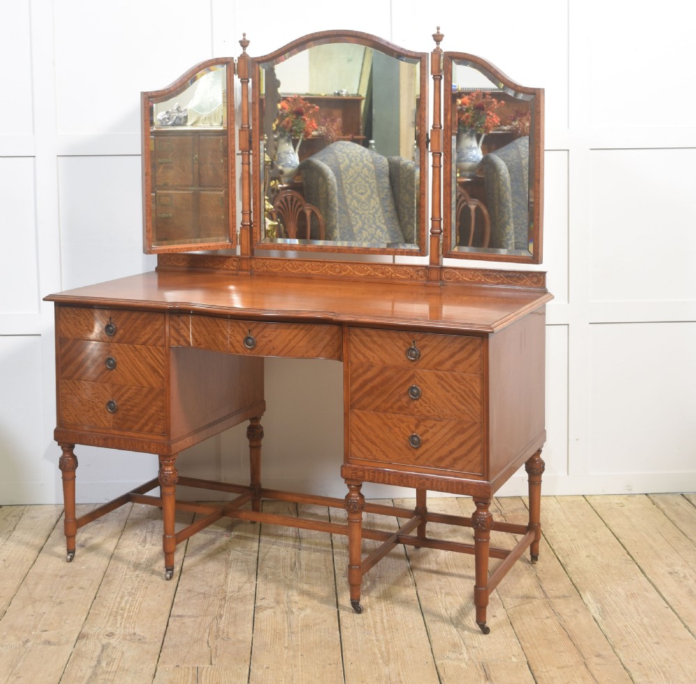 An antique satinwood dressing table featuring a triptych mirror, chevron marquetry drawers, brass ring handles, and turned legs on castors. View V