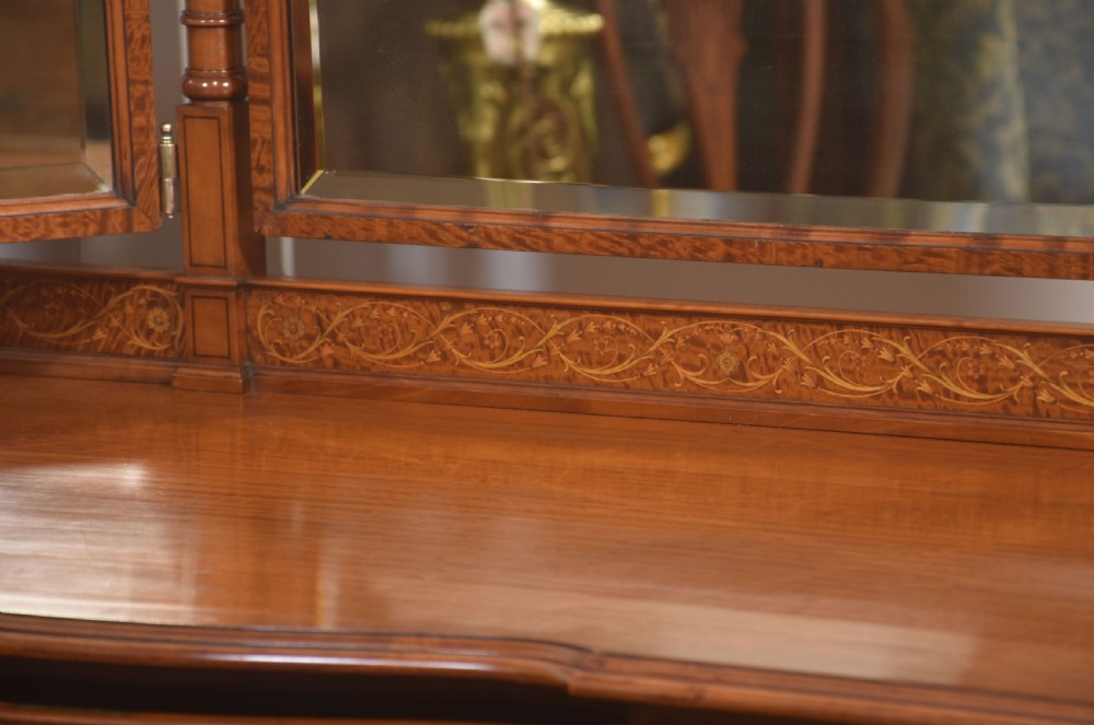 An antique satinwood dressing table featuring a triptych mirror, chevron marquetry drawers, brass ring handles, and turned legs on castors. View VIII