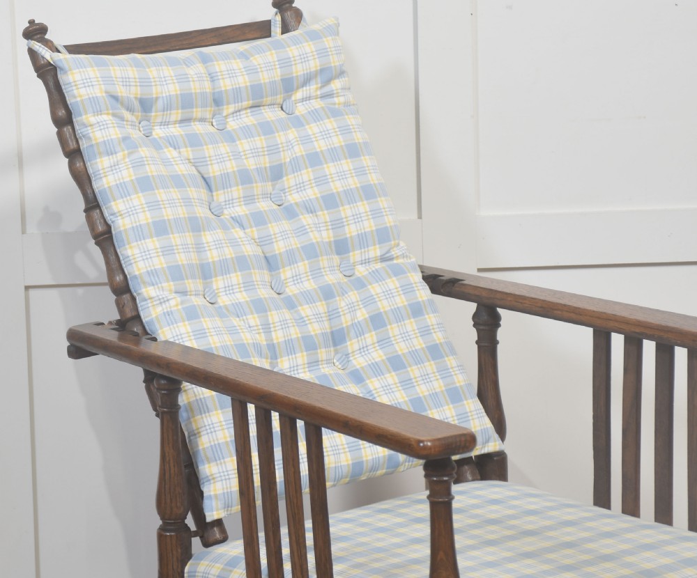 A dark oak reclining armchair featuring turned posts, vertical side slats, and a blue and yellow plaid upholstered cushion. View VII