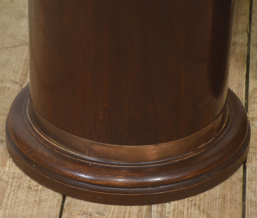 A pair of cylindrical dark mahogany umbrella stands featuring brass binding bands and brass lion mask ring handles. View VI