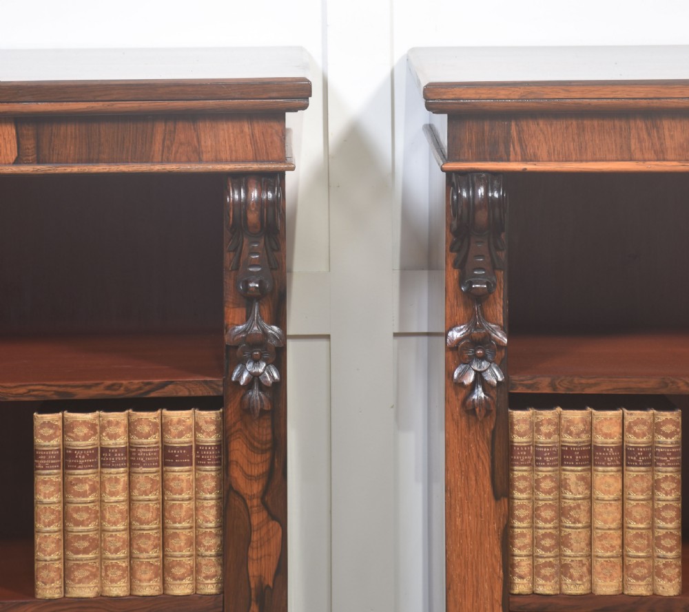 A pair of 19th-century rosewood open bookcases featuring carved side corbels and three open shelves each on a solid plinth base. View II