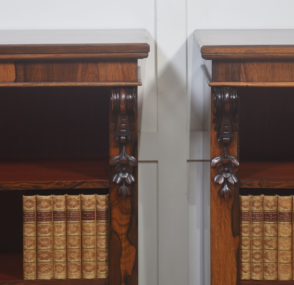 A pair of 19th-century rosewood open bookcases featuring carved side corbels and three open shelves each on a solid plinth base. View V
