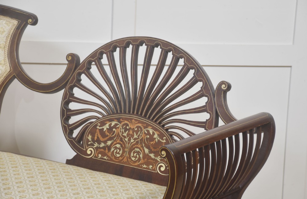 An antique mahogany settee featuring an openwork fan back with floral marquetry inlay, slatted side rails, and a cream pattern upholstered seat. View VIII