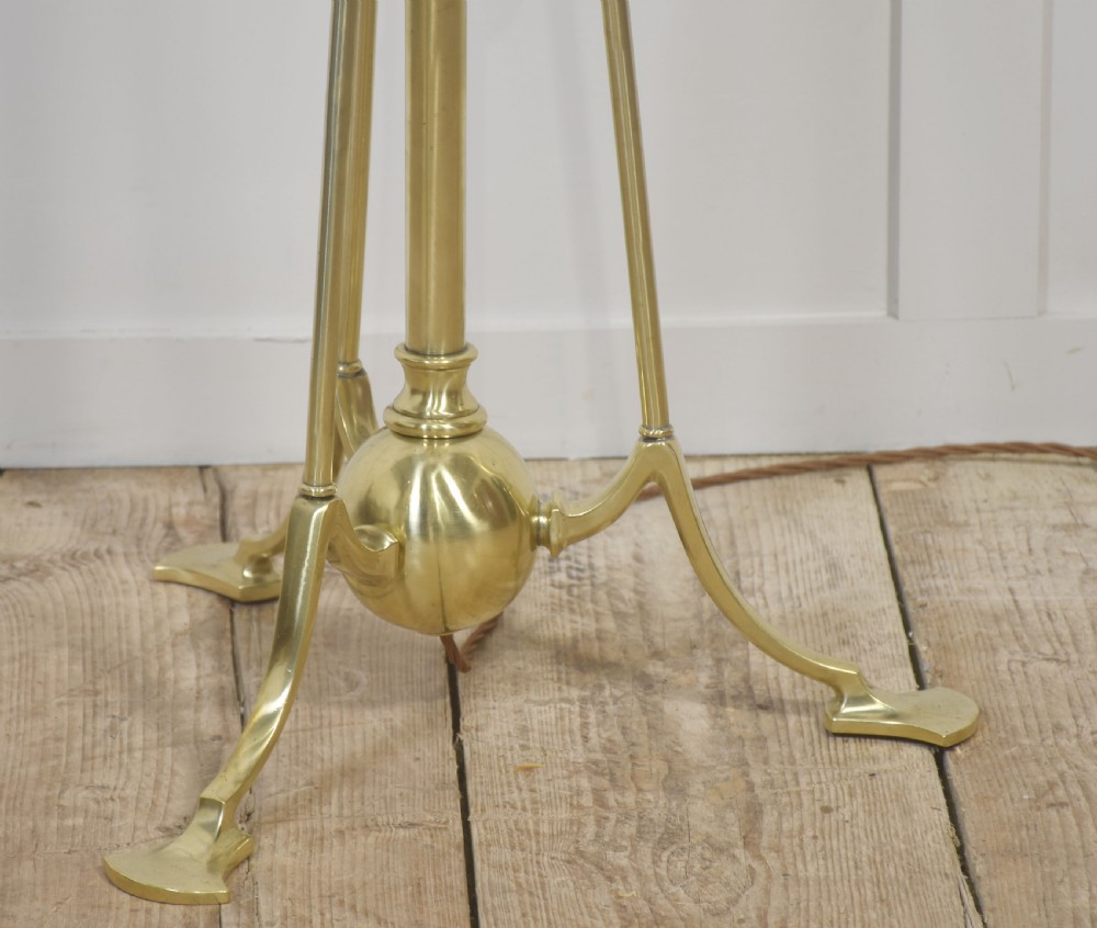 An Arts and Crafts style brass tripod floor lamp with an adjustable stem and a pleated off-white fabric shade. View V