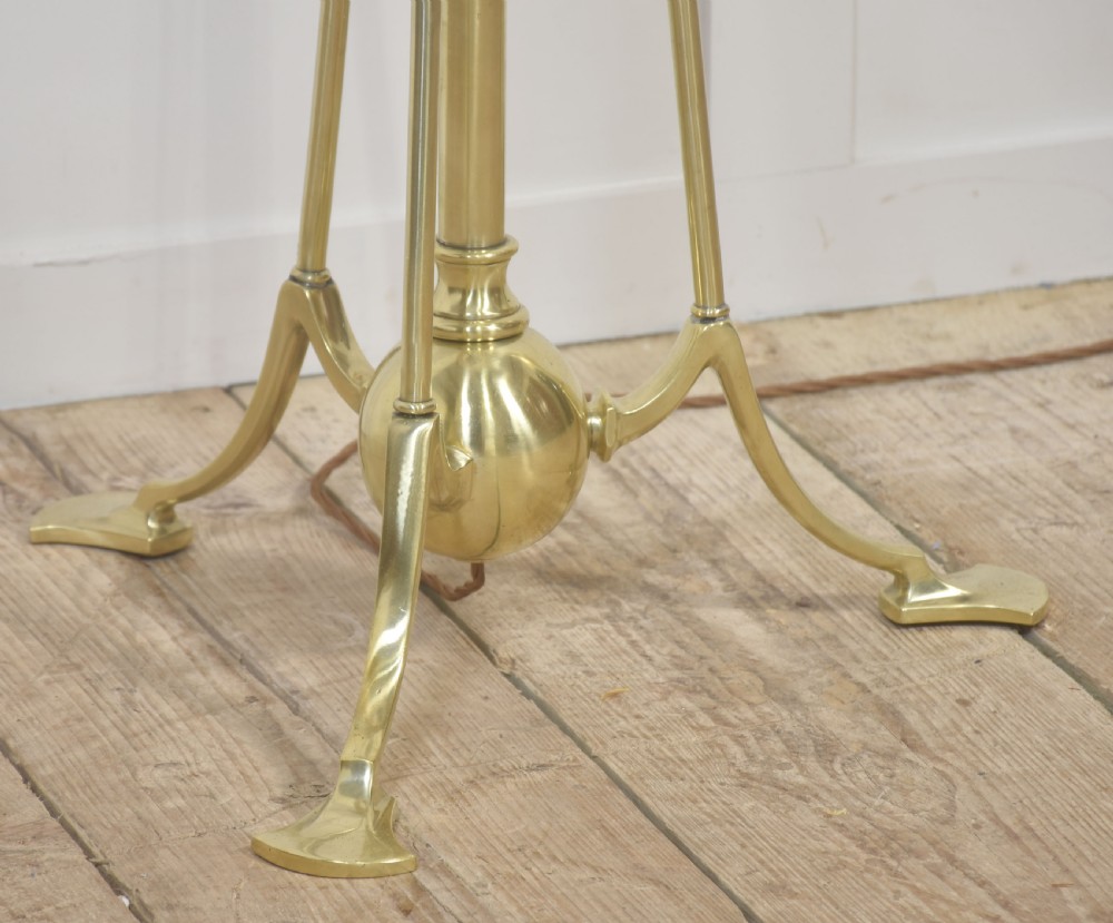 An Arts and Crafts style brass tripod floor lamp with an adjustable stem and a pleated off-white fabric shade. View VI