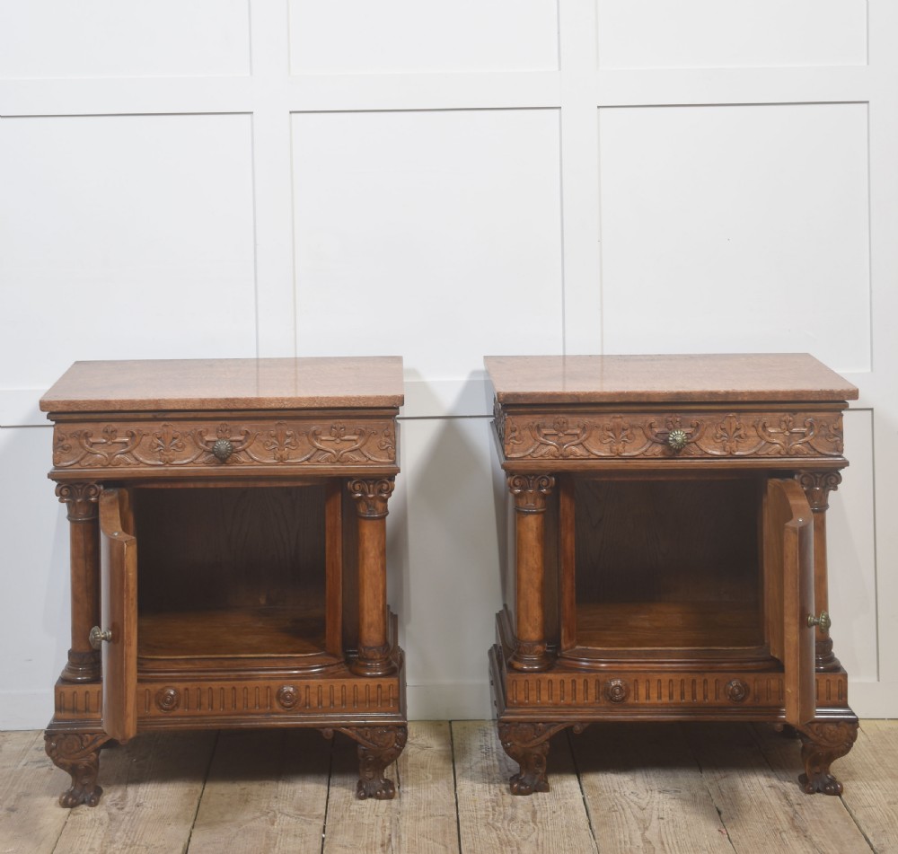 A pair of carved warm brown mahogany bedside cabinets featuring classical columns, frieze carvings, and single panel doors on carved feet. View VII