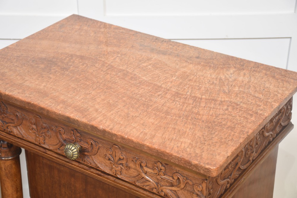 A pair of carved warm brown mahogany bedside cabinets featuring classical columns, frieze carvings, and single panel doors on carved feet. View XI