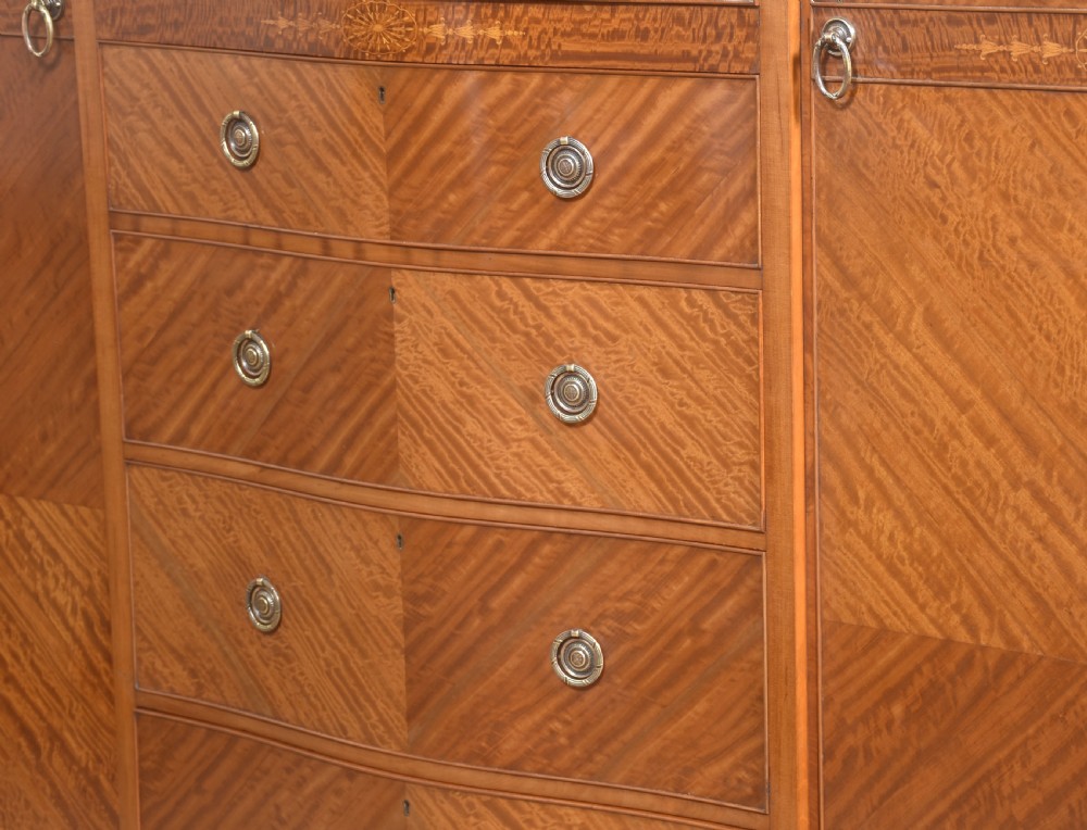 A large Edwardian inlaid satinwood compactum wardrobe featuring a central section with cupboard doors above four drawers, flanked by two full-length side doors. View VII