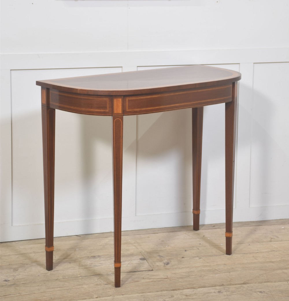 A demilune inlaid mahogany console table with square tapered legs shown beneath a matching rectangular crossbanded mahogany wall mirror. View III