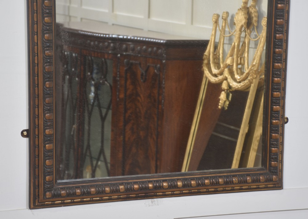 A large rectangular Neoclassical wall mirror featuring a carved giltwood frame topped with a decorative mascaron and acanthus scroll crest. View VII