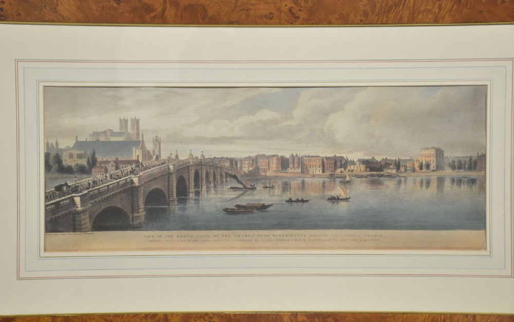 A set of six matching framed rectangular prints displaying panoramic views of the River Thames set within rich burr walnut frames with light cream mounts. View XI
