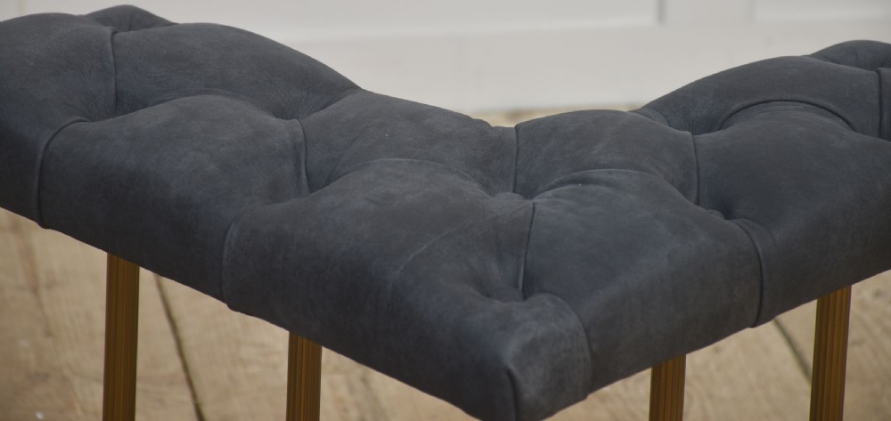 A solid brass club fender featuring twin button-upholstered grey corner seats supported by vertical brass spindles and a dipped central railing. View VIII