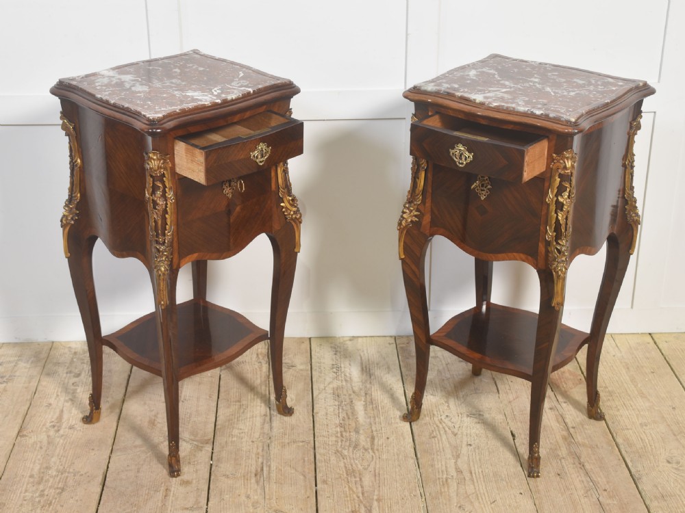 A pair of French Louis XV style bedside cabinets crafted with kingwood parquetry, dark marble tops, cabriole legs, and bronze mounts. View VII