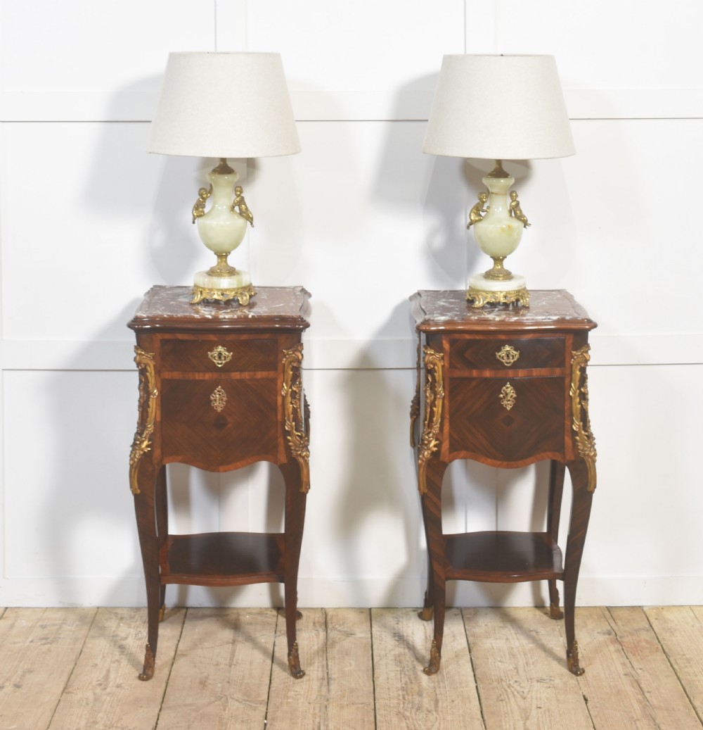 A pair of French Louis XV style bedside cabinets crafted with kingwood parquetry, dark marble tops, cabriole legs, and bronze mounts. View IX