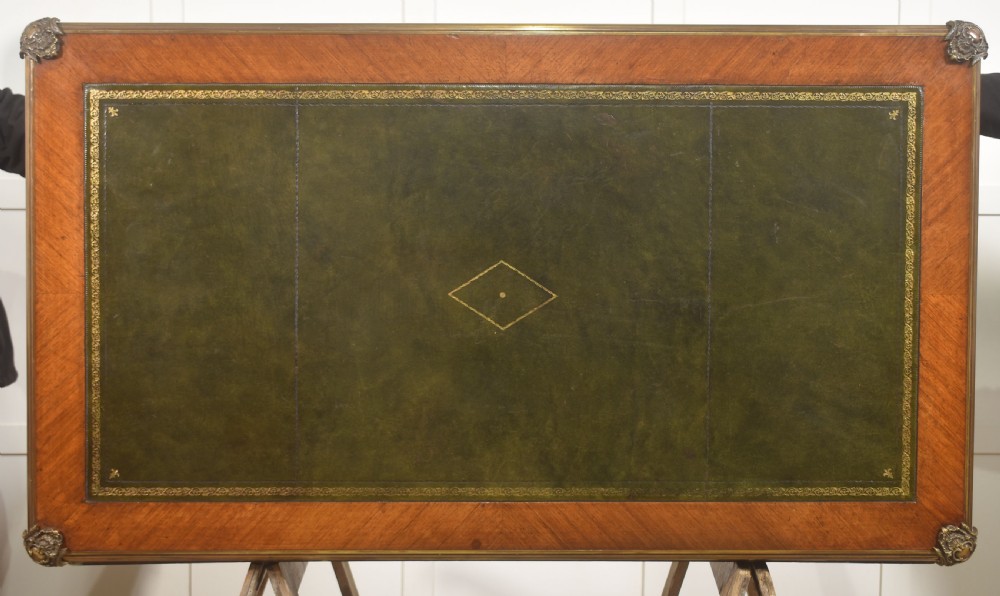A French Louis XV style wooden bureau plat featuring three frieze drawers, gilt-bronze ormolu mounts, cabriole legs, and a green leather writing surface. View XVII