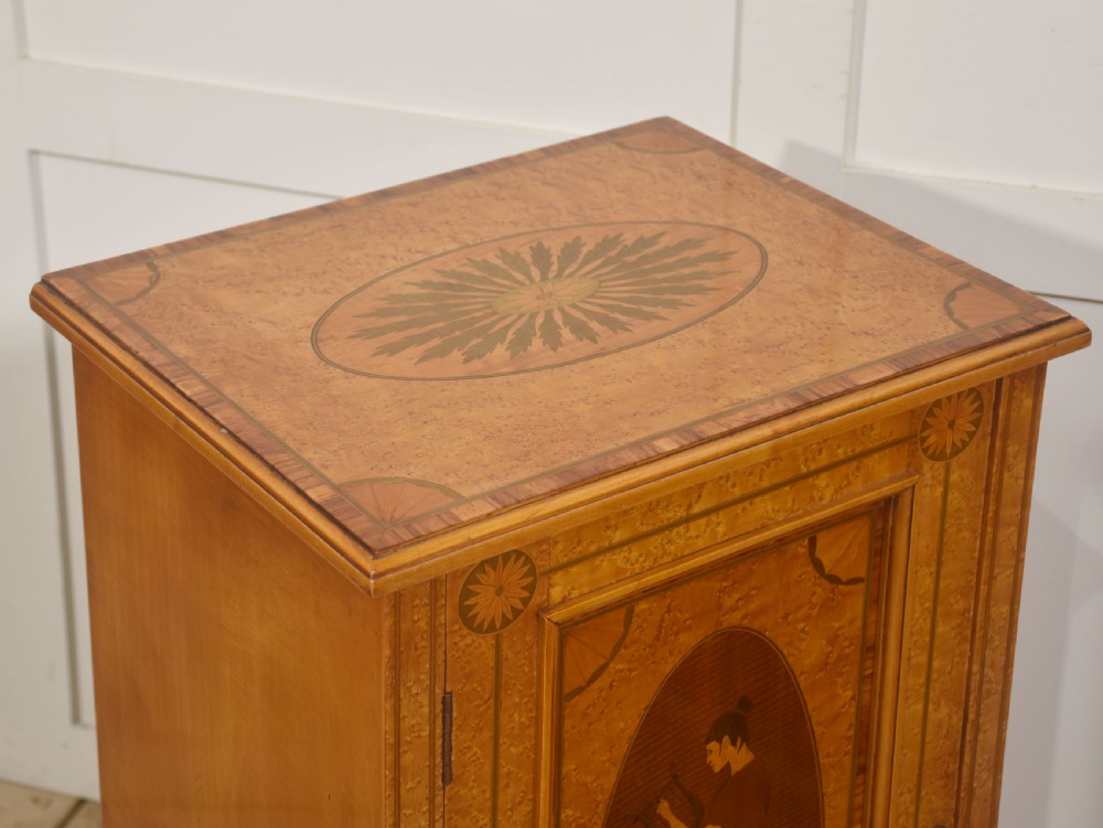 A pair of golden satinwood Neo-Classical Revival bedside cabinets featuring oval marquetry panels depicting classical figures playing instruments. View IV