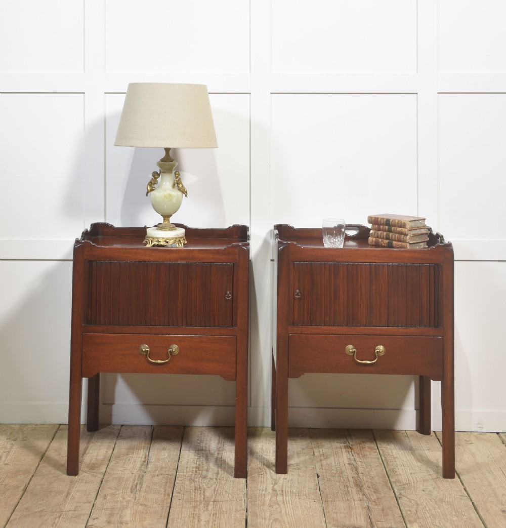 A pair of dark warm mahogany bedside cabinets featuring gallery tops with cutout handles, reeded tambour doors, and single lower drawers with brass handles. View II