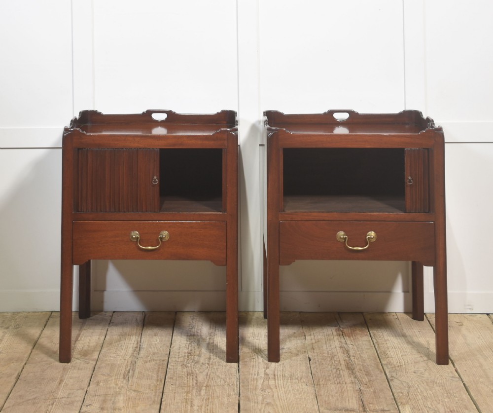 A pair of dark warm mahogany bedside cabinets featuring gallery tops with cutout handles, reeded tambour doors, and single lower drawers with brass handles. View V