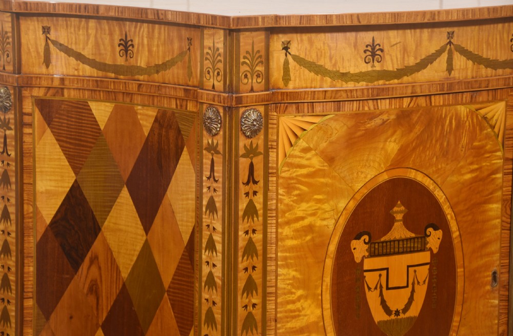 A Neoclassical demi-lune side cabinet crafted from golden satinwood featuring detailed urn marquetry inlays on two doors and tapered square legs. View VI