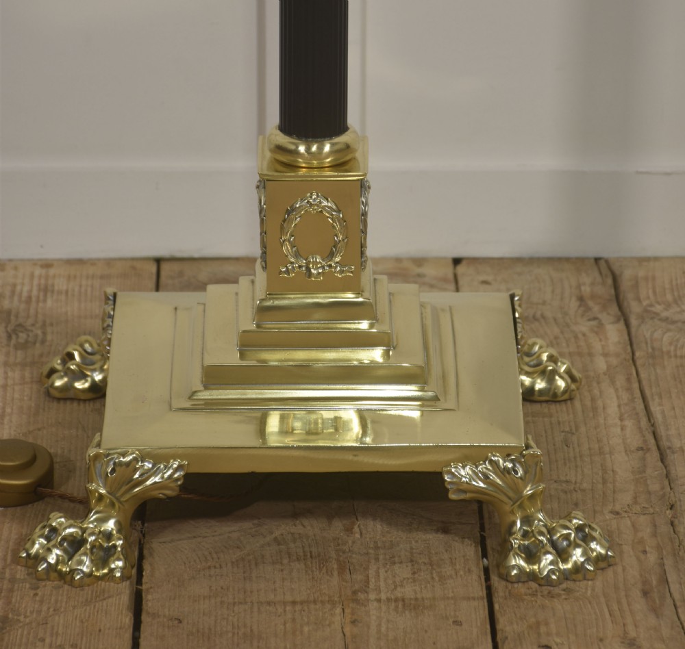 A Neoclassical standard lamp with a black central column, brass Corinthian capital, stepped square claw-foot base, and a scalloped cream fringed shade. View VI