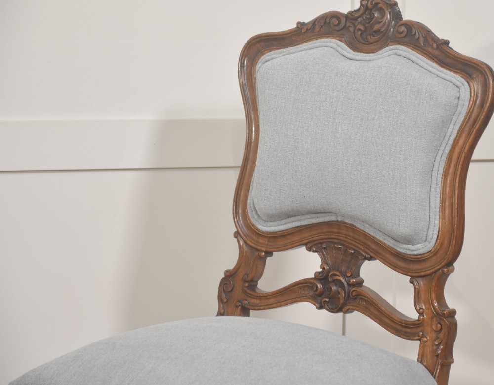A pair of carved walnut Louis XV style side chairs with light grey upholstery on the seats and padded backrests. View II