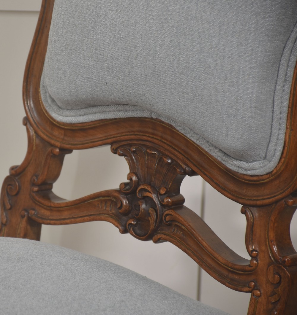 A pair of carved walnut Louis XV style side chairs with light grey upholstery on the seats and padded backrests. View V