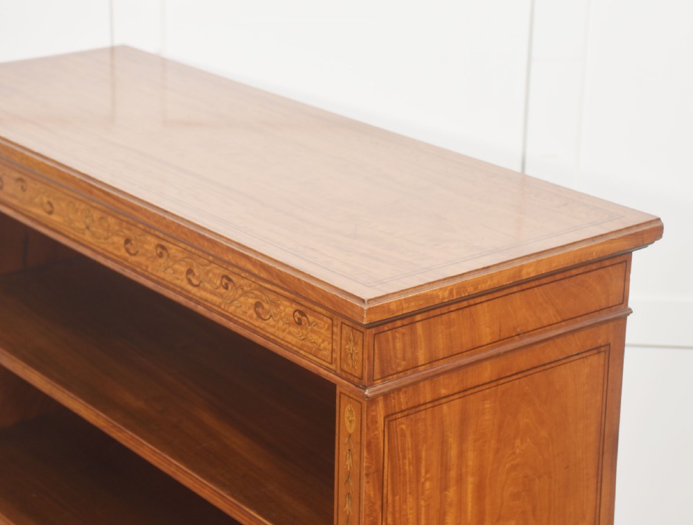 A low satinwood open bookcase featuring three shelves and a decorative inlaid floral frieze across the top. View XIII